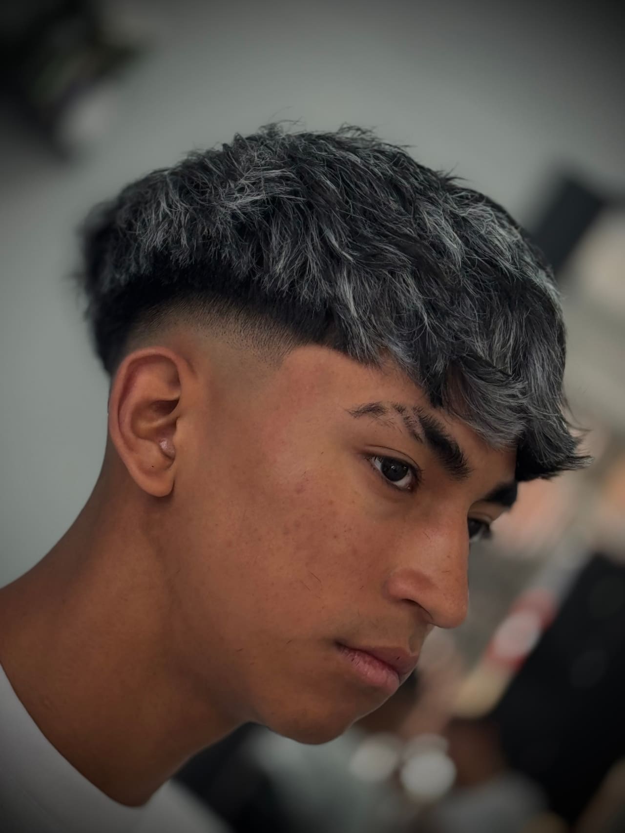 Mechas plata sobre corte texturizado con fade