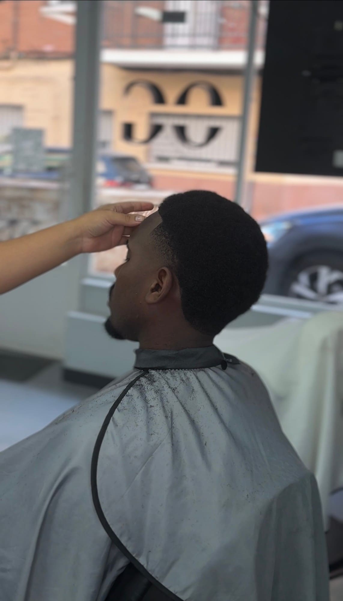 Fade bajo sobre pelo afro, perfilado a navaja